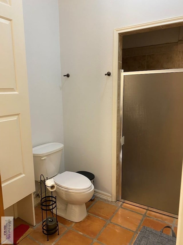 417 SE Verbena Ln Unit 23, La Feria, TX 78559 - bathroom with a shower stall, toilet, and tile patterned flooring