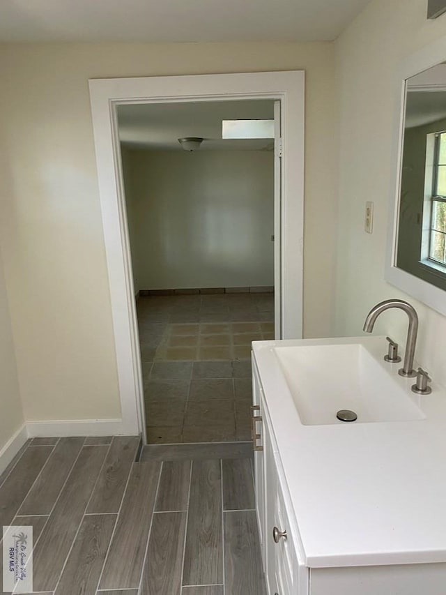 417 SE Verbena Ln Unit 23, La Feria, TX 78559 - bathroom featuring wood finished floors, vanity, and baseboards