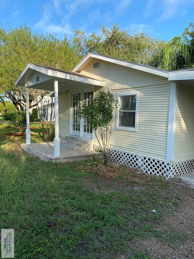 417 SE Verbena Ln Unit 23, La Feria, TX 78559 - back of house featuring a lawn and a patio area