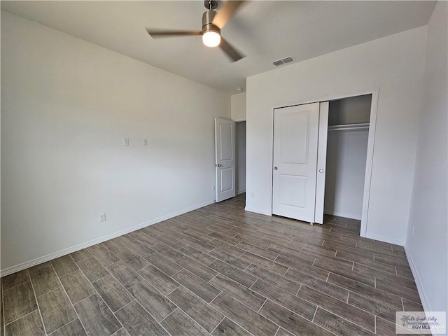 unfurnished bedroom with dark hardwood / wood-style flooring, a closet, and ceiling fan