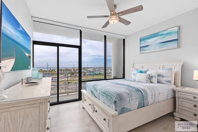 bedroom with a wall of windows and a ceiling fan