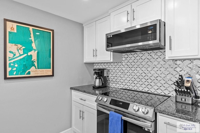 kitchen featuring decorative backsplash, white cabinets, appliances with stainless steel finishes, and dark stone counters