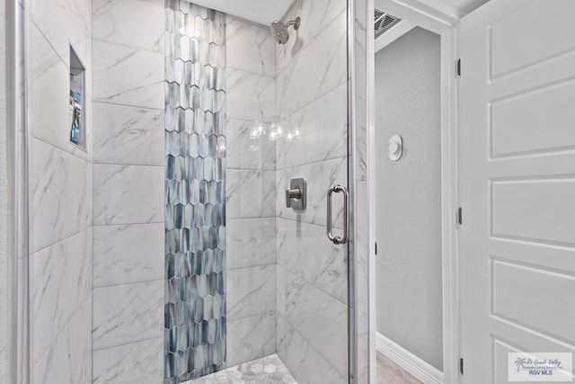 bathroom featuring visible vents, baseboards, and a shower stall