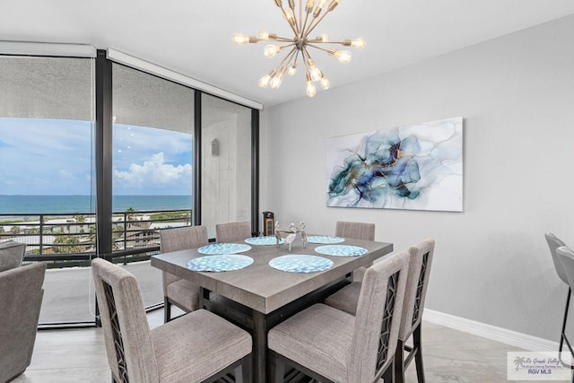 dining space featuring expansive windows, baseboards, a water view, and a chandelier