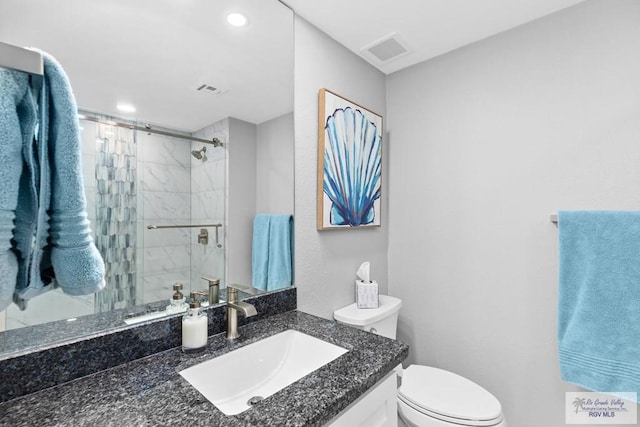 full bathroom with vanity, toilet, visible vents, and a stall shower