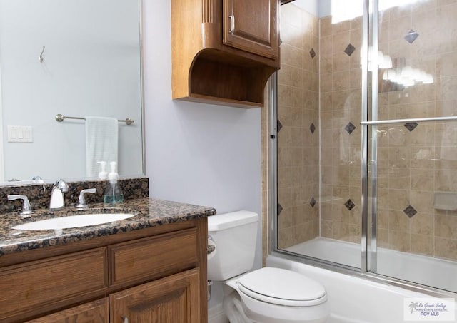 full bathroom with vanity, shower / bath combination with glass door, and toilet