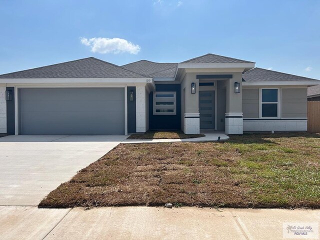109 Poppy St, Los Fresnos, TX 78566 - view of front of home featuring an attached garage, concrete driveway, roof with shingles, and a front lawn