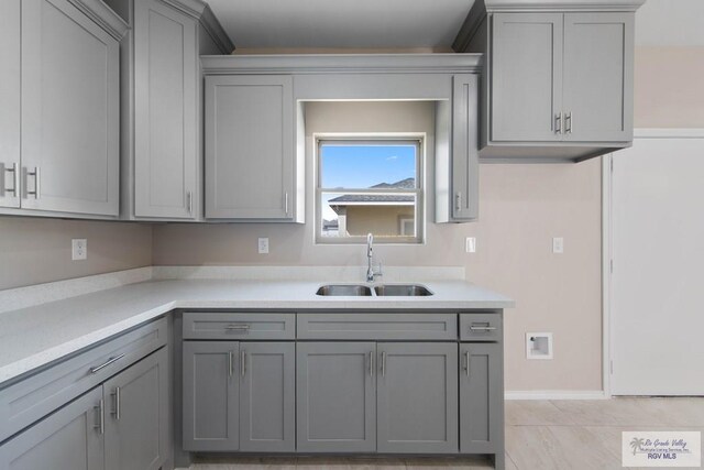 kitchen featuring gray cabinetry, sink, and a textured ceiling