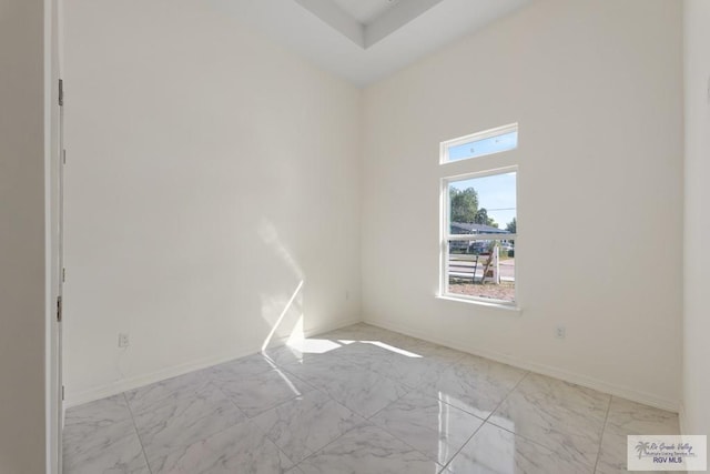 empty room featuring baseboards and marble finish floor