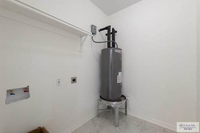 clothes washing area with electric dryer hookup, marble finish floor, laundry area, and water heater