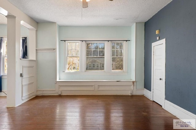 unfurnished room featuring a textured ceiling, dark hardwood / wood-style flooring, and ceiling fan