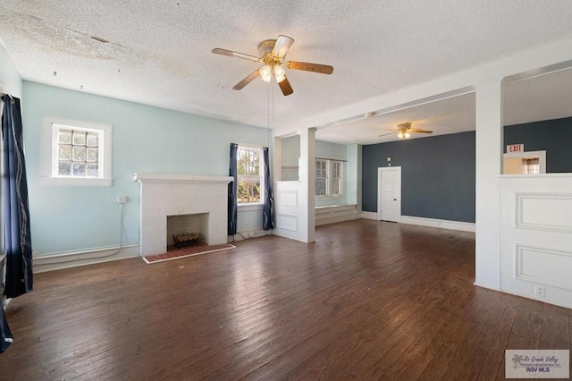 unfurnished living room featuring a textured ceiling, dark hardwood / wood-style flooring, and a wealth of natural light