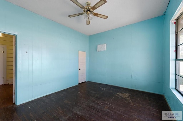 empty room with ceiling fan and dark wood-type flooring