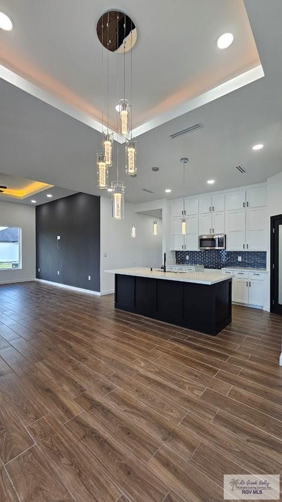 kitchen featuring pendant lighting, dark hardwood / wood-style floors, and white cabinetry