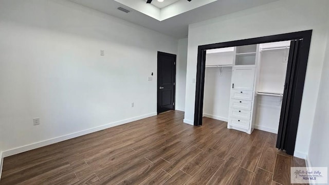 unfurnished bedroom with dark hardwood / wood-style floors and a closet