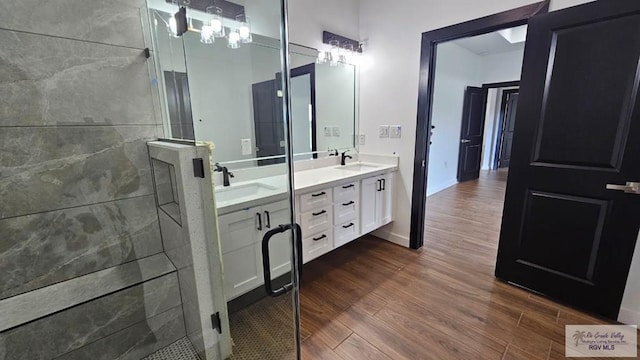 bathroom featuring hardwood / wood-style floors, vanity, and a shower with shower door