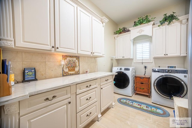 laundry area featuring washing machine and dryer and cabinets