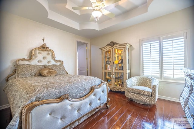 bedroom featuring a tray ceiling, ceiling fan, and dark hardwood / wood-style floors