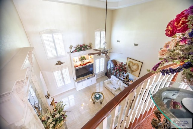 living room featuring ceiling fan and a high ceiling