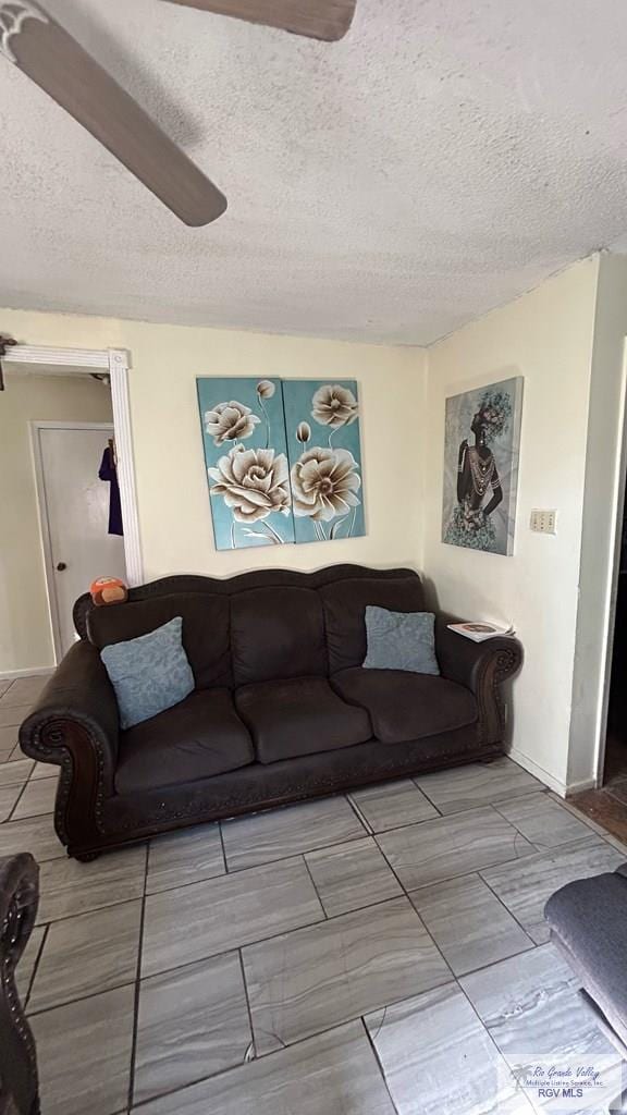 living room with a textured ceiling and ceiling fan