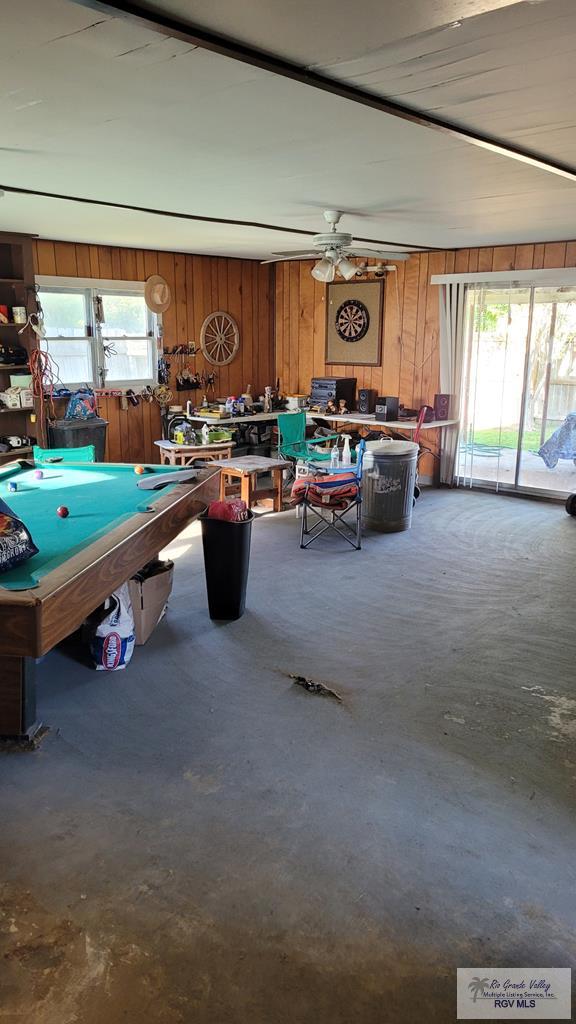 409 E Pine Ave Unit 0, La Feria, TX 78559 - rec room with wood walls, ceiling fan, pool table, and concrete floors