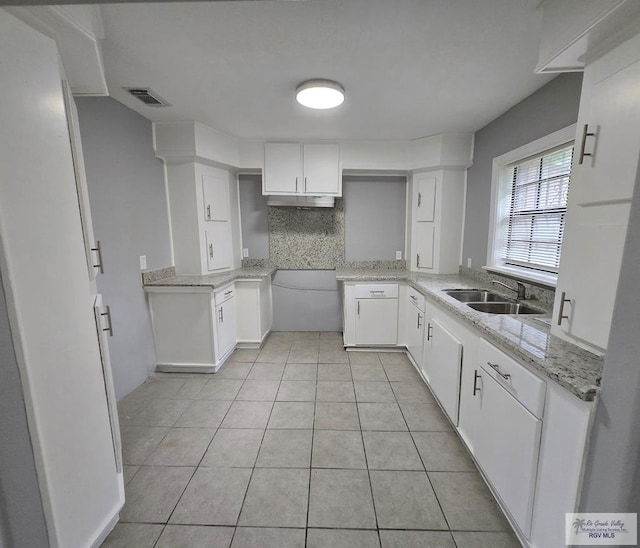 1164 Vera Ave, Brownsville, TX 78521 - kitchen with a sink, light tile patterned floors, white cabinets, and under cabinet range hood