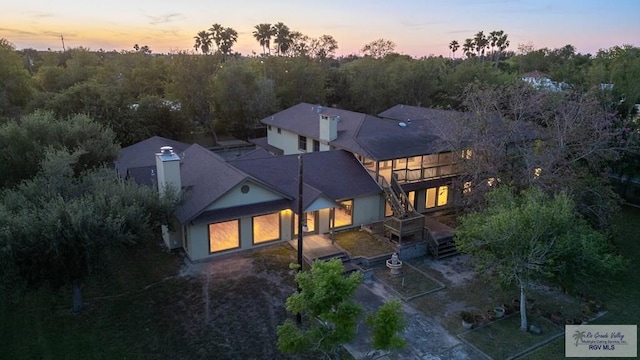 back house at dusk featuring a garage