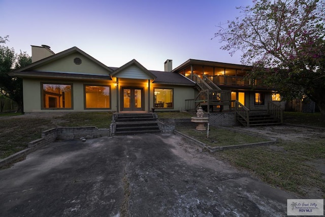 view of front of home with a sunroom, french doors, and a patio