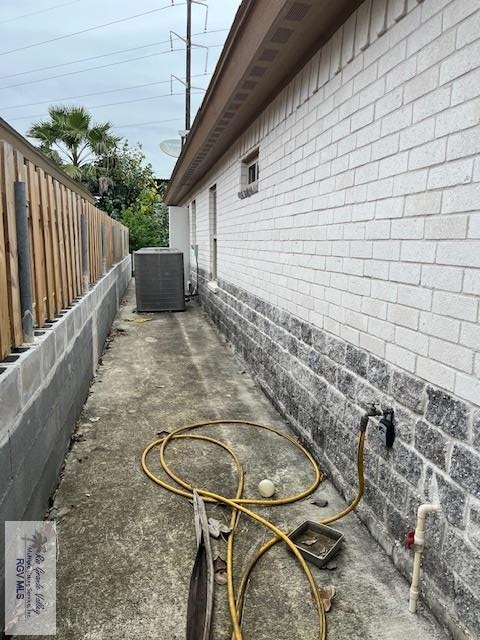 1972 Baja Dr Unit 4, Los Fresnos, TX 78566 - view of home's exterior with central air condition unit, fence, and a patio area