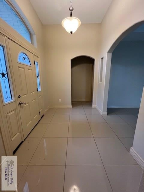 1972 Baja Dr Unit 4, Los Fresnos, TX 78566 - entrance foyer featuring arched walkways, baseboards, and light tile patterned flooring