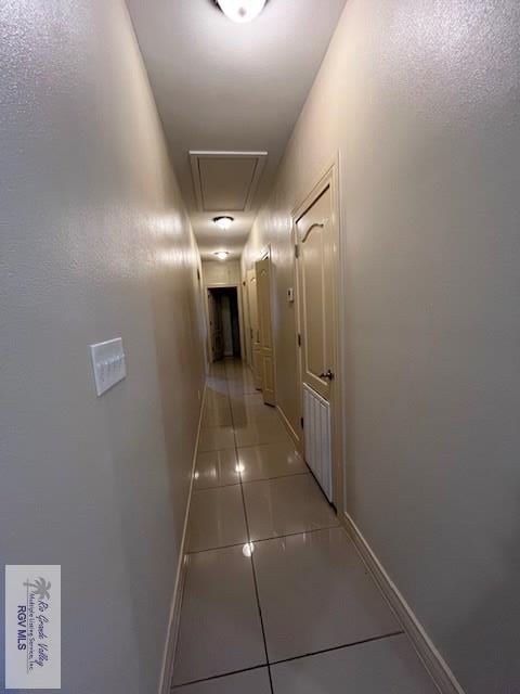1972 Baja Dr Unit 4, Los Fresnos, TX 78566 - hallway with attic access, light tile patterned floors, and baseboards