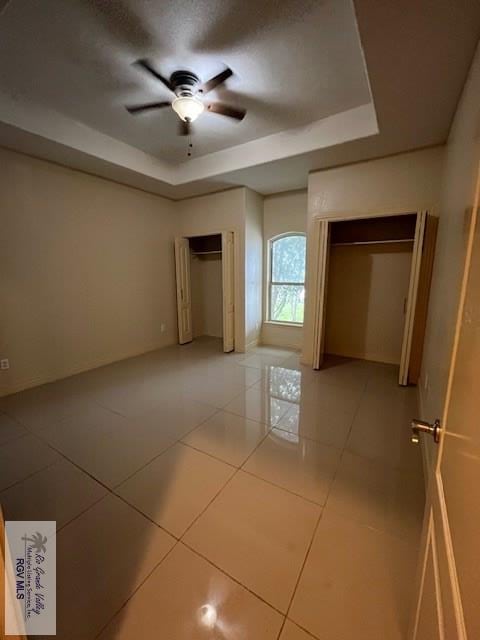 1972 Baja Dr Unit 4, Los Fresnos, TX 78566 - unfurnished bedroom with a tray ceiling, light tile patterned floors, and a ceiling fan