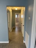 hallway with dark tile patterned flooring