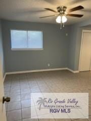 tiled empty room featuring ceiling fan