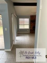 corridor featuring lofted ceiling with beams and light tile patterned floors