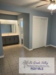 unfurnished bedroom featuring ceiling fan, dark tile patterned flooring, and a closet