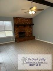 unfurnished living room featuring tile patterned flooring, a brick fireplace, lofted ceiling with beams, and ceiling fan