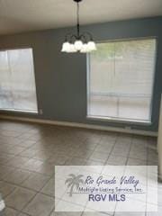 tiled dining area with a chandelier