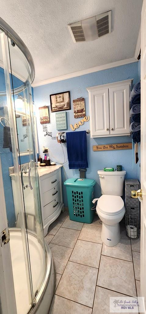 full bath featuring a stall shower, a textured ceiling, toilet, ornamental molding, and visible vents