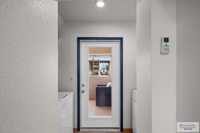 131 Windward Dr, Port Isabel, TX 78578 - entryway with washing machine and clothes dryer and a textured wall