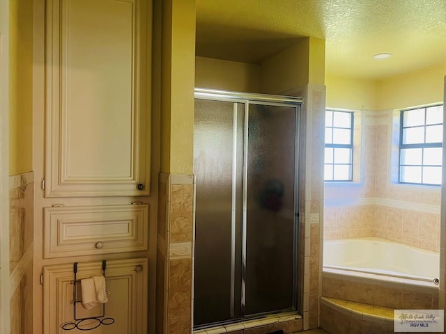 bathroom with a textured ceiling and plus walk in shower