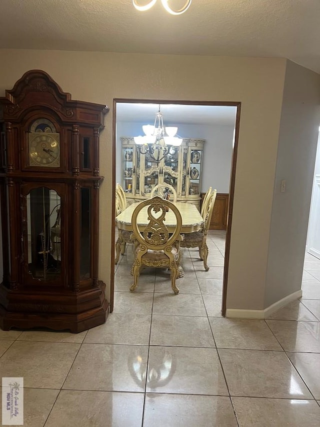 unfurnished dining area with light tile patterned floors, a textured ceiling, and a chandelier