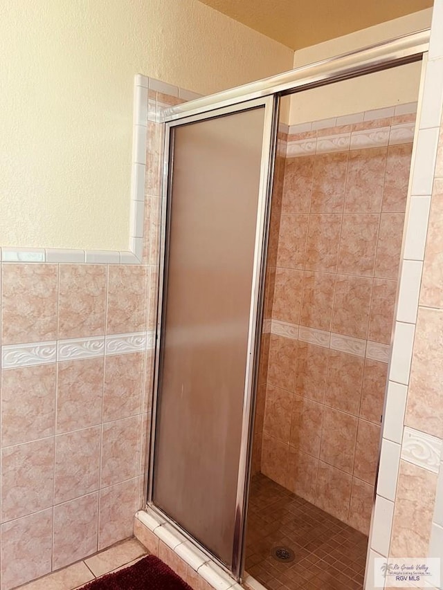 bathroom with a shower with door