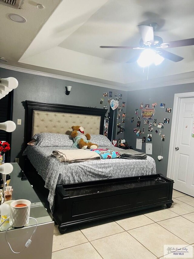 bedroom featuring light tile patterned floors, a tray ceiling, ceiling fan, and ornamental molding