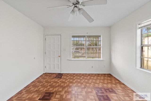 empty room with ceiling fan and baseboards