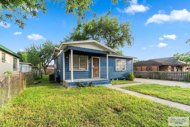 view of front facade with a front yard, central air condition unit, and fence private yard