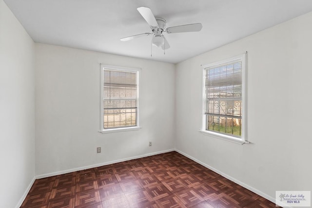unfurnished room featuring ceiling fan, plenty of natural light, and baseboards