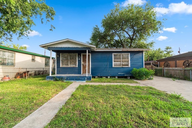 bungalow with fence, covered porch, and a front yard