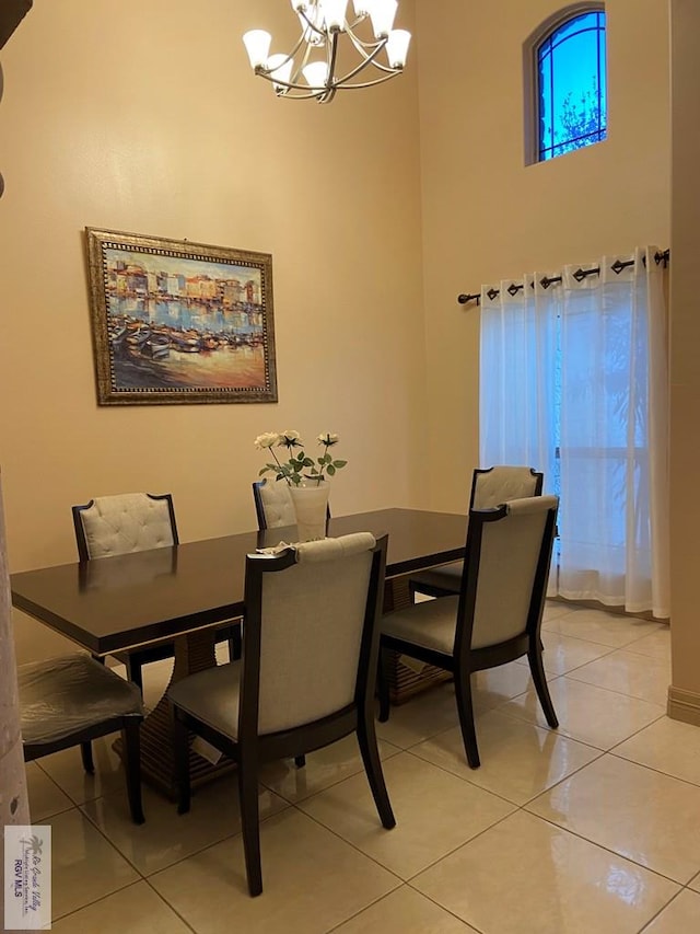 dining area featuring a high ceiling, a chandelier, and light tile patterned floors