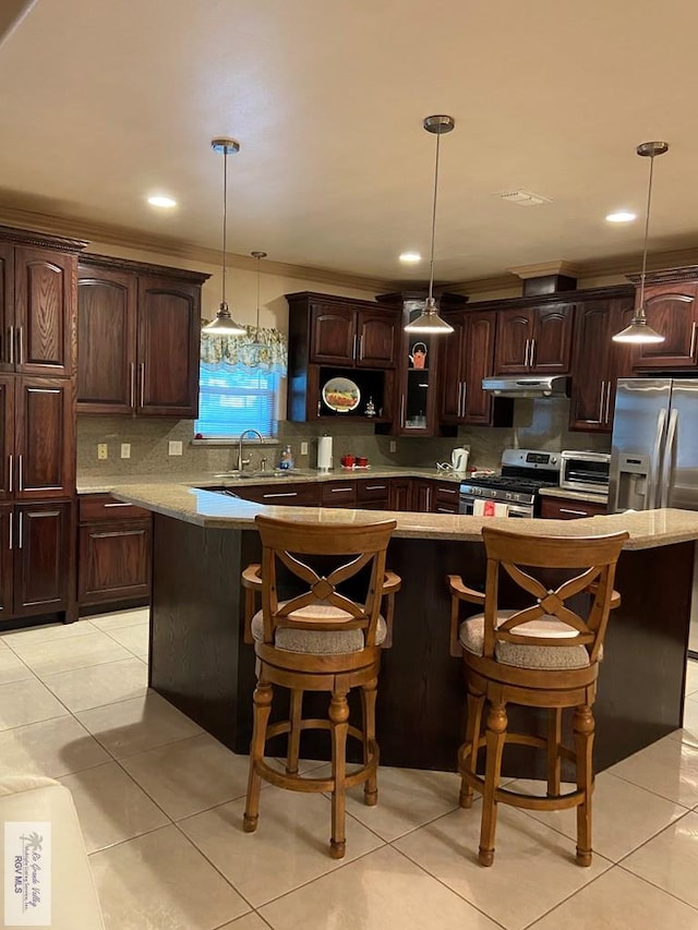 kitchen featuring a center island, pendant lighting, stainless steel appliances, dark brown cabinets, and decorative backsplash